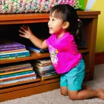콩지래빗 DVD 및 스트리밍 서비스 - A joyful 6-year-old girl, wearing a modest, bright pink t-shirt and comfortable shorts, kneels eager...